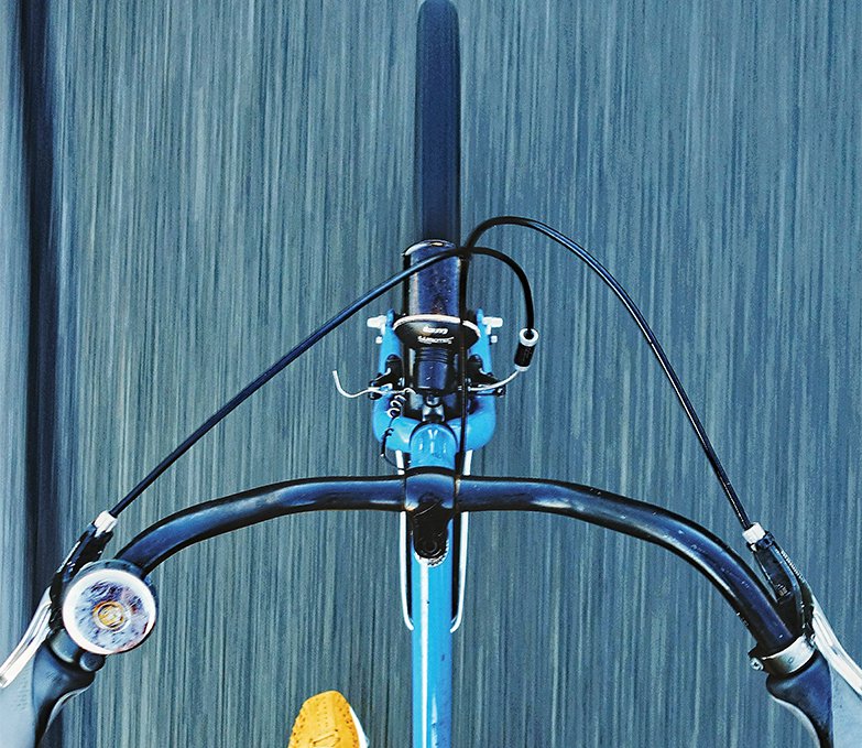 Low Section Of Man Riding Bicycle On Road