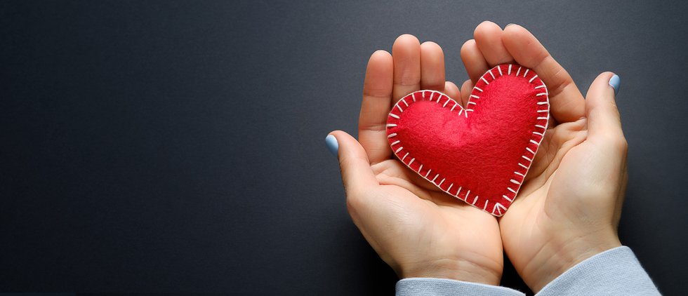 The Girl Is Holding A Red Handmade Heart On A Black Background. Banner.