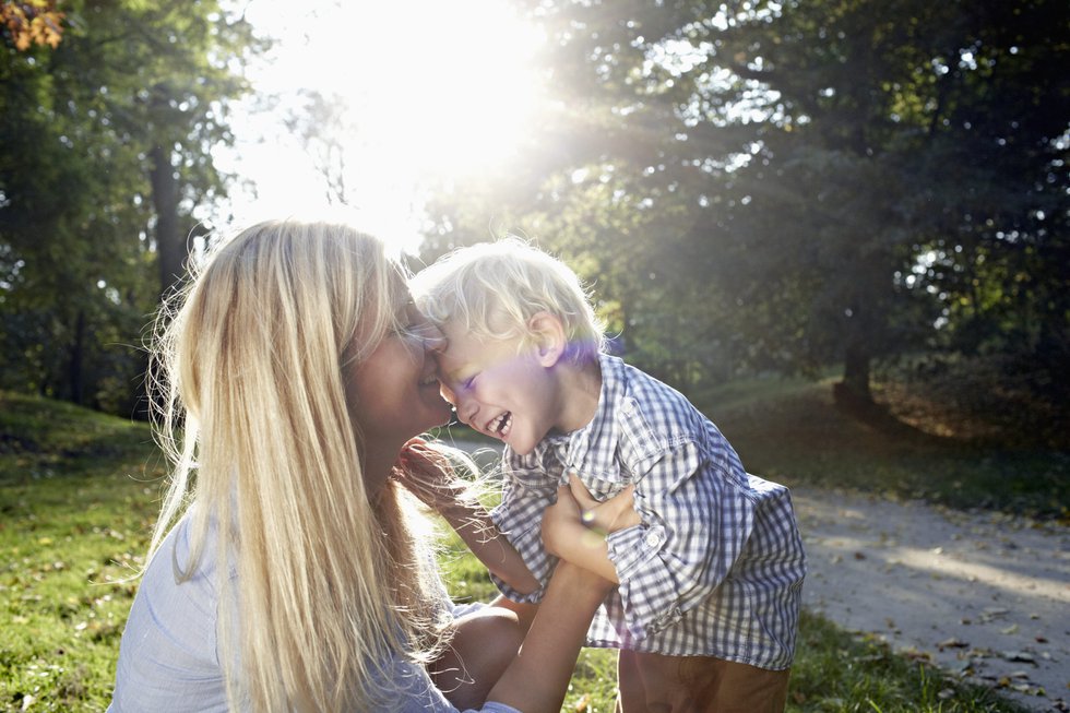 mother and her child cuddling in a park