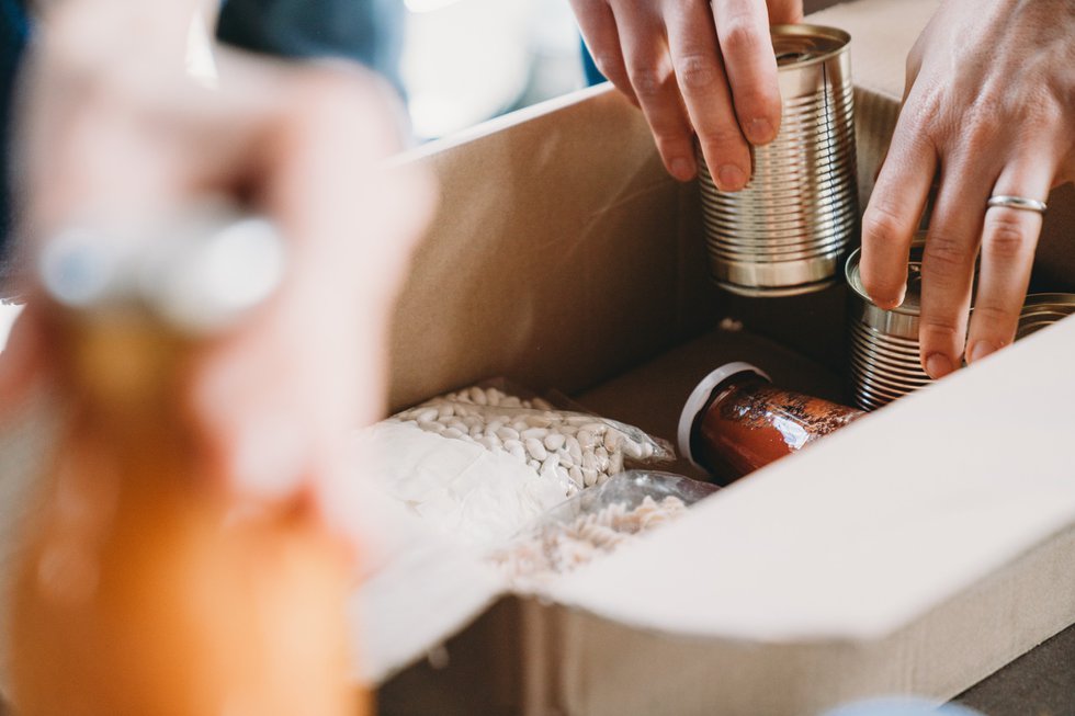 Close up photo of volunteers preparing donation boxes with food at the food and clothes bank