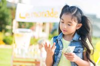 Young girl counts money made from lemonade stand