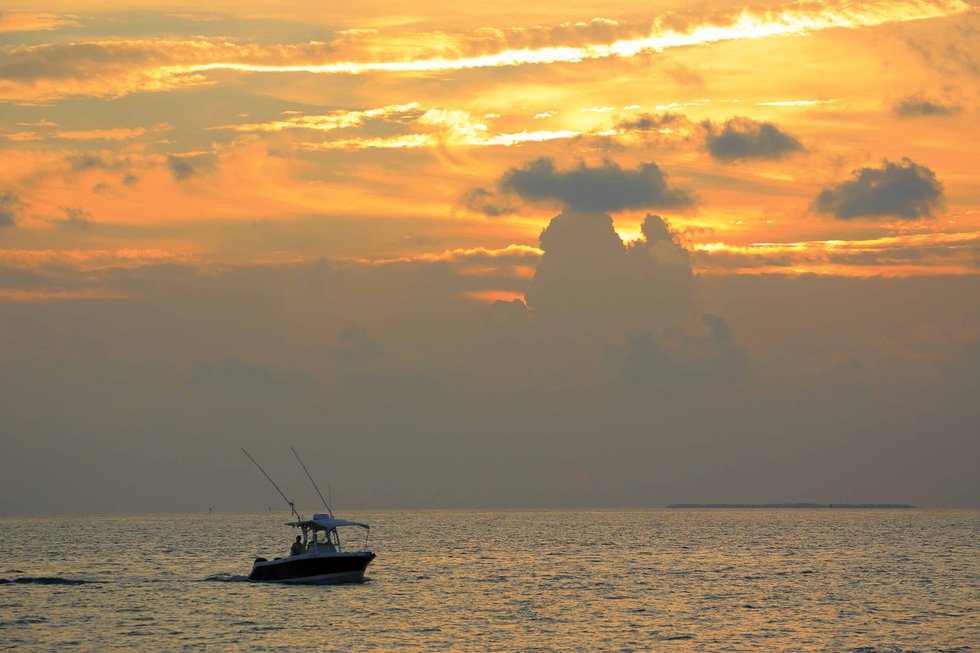 A fishing boat sailing in sunset time