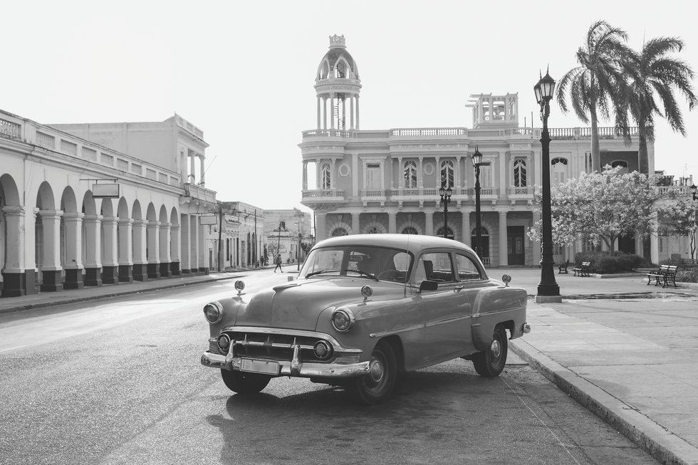 Black and white photo of vintage car in front of building