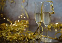 Two champagne glasses surrounded by gold ribbon