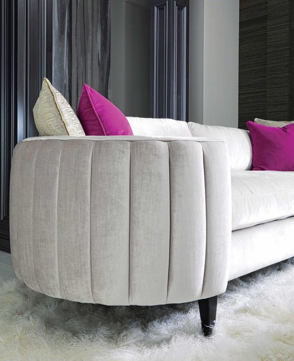 Light grey couch with pink pillows and white rug.jpeg