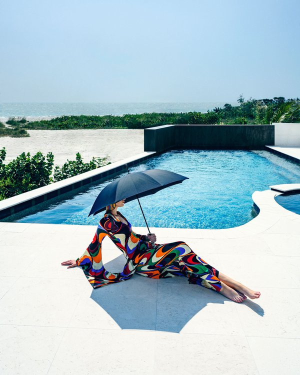 Model posing in colorful dress by the pool with umbrella.jpg