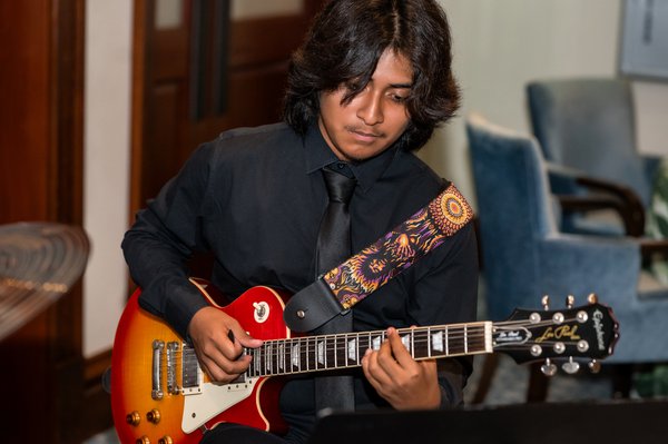 Boy playing guitar at Zoo Gala patron party.jpg