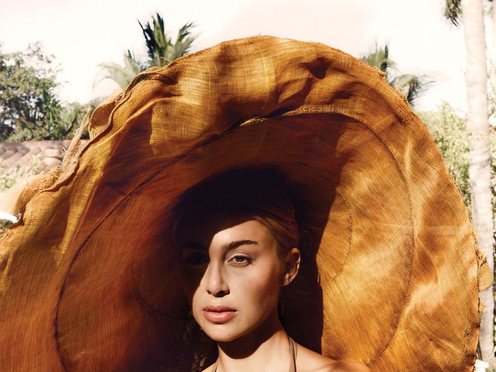 Hotel Escalante by the pool model wearing brown extra large hat