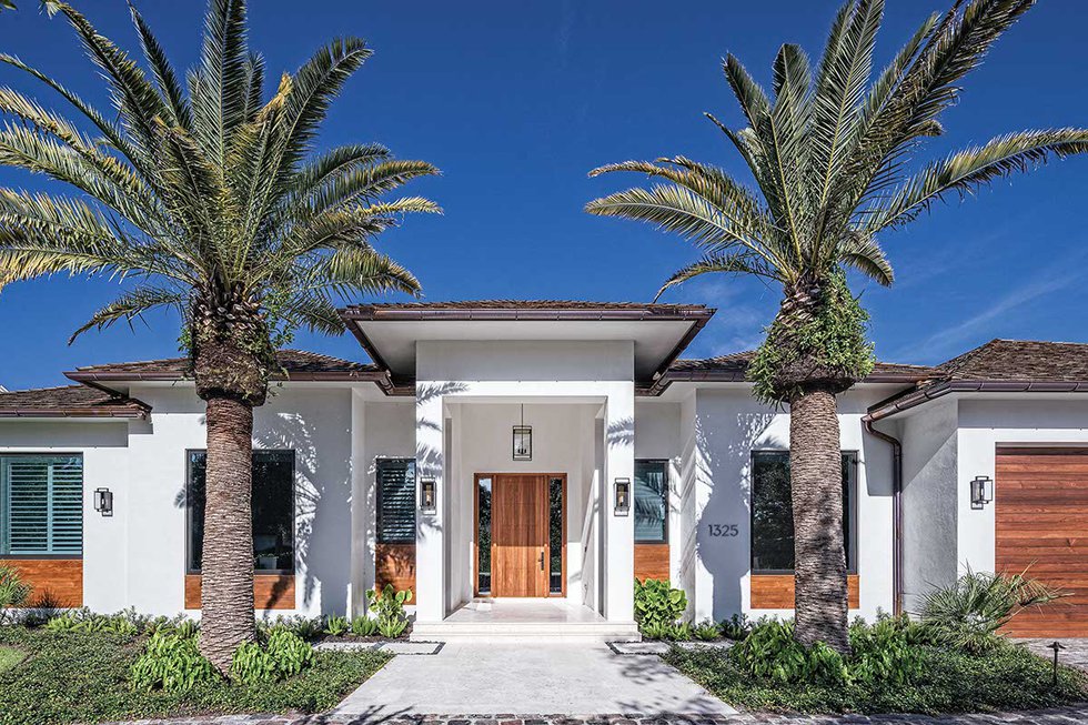 front door of home featuring wood door john kukk design