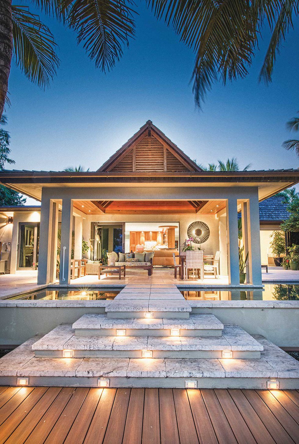 outdoor space during dusk featuring a pool and chairs john kukk design