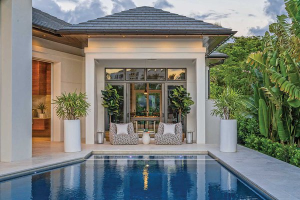 Shell stone pool deck with cypress outdoor kitchen in the background.jpeg