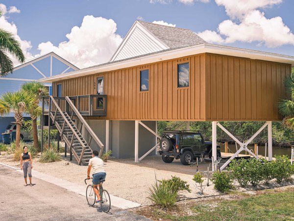 Man bicycling and woman standing in front of home on canal.jpeg