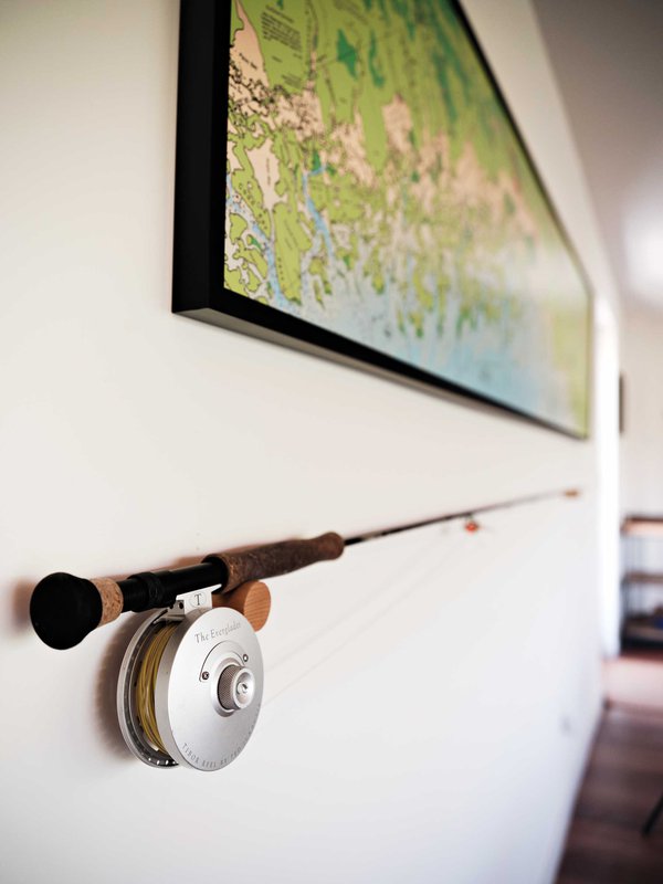 Fishing rod hung on wall with map above.jpeg