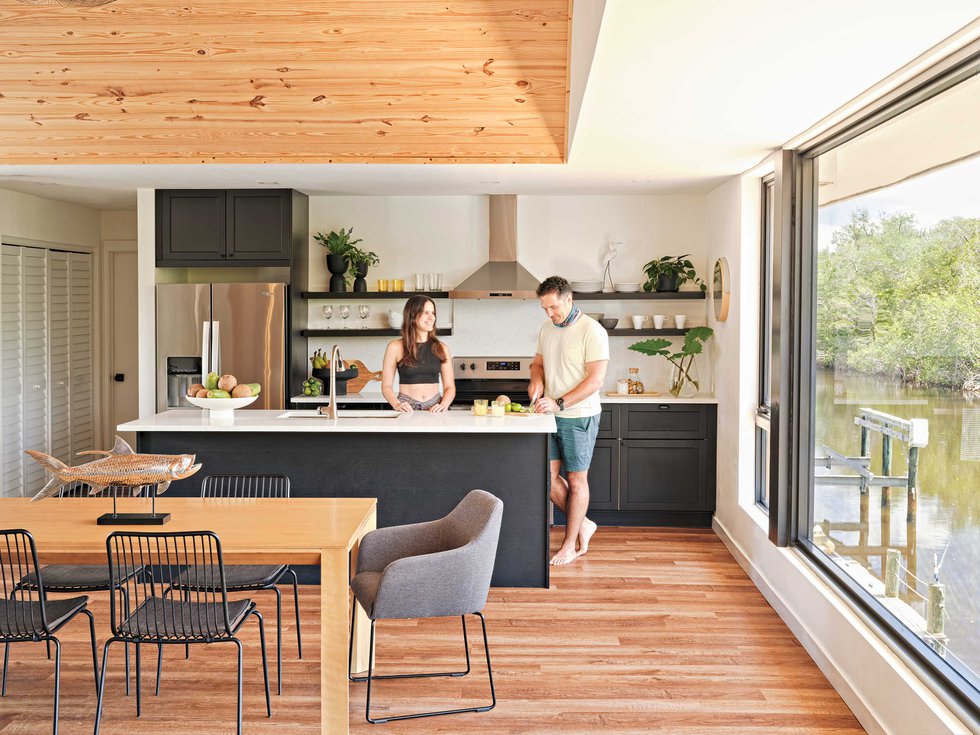 Kitchen with wooden floors and black cabinetry overlooking the canal.jpeg