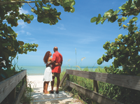 beach goers embrace and over look a beach naples beaches