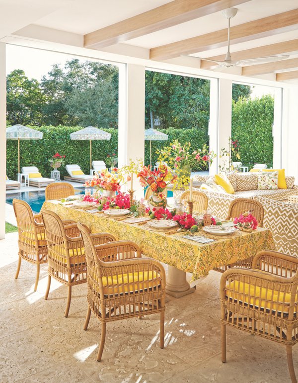 Outdoor living space with yellow decor and floral arrangements.jpg