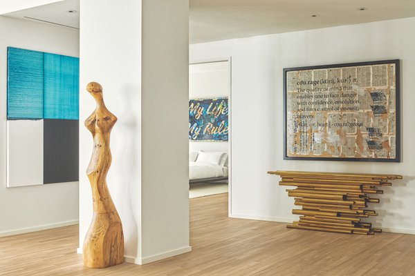 White room with wooden sculpture and pictures on wall.jpg