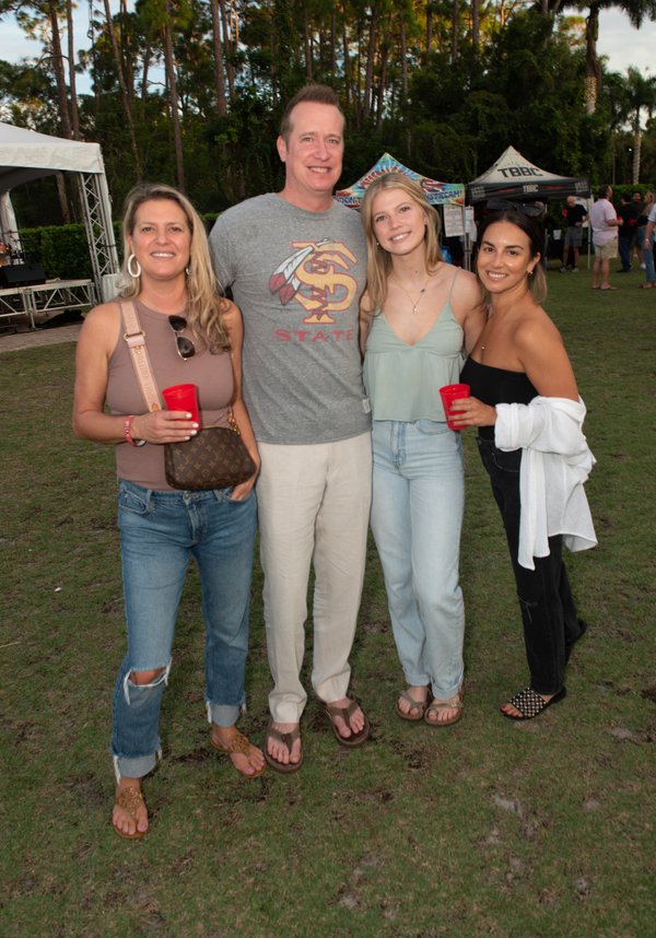 4 people posing for photo at outdoor event