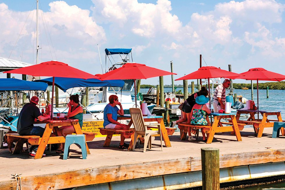 People sitting under umbrellas at Cortez harbor, Florida